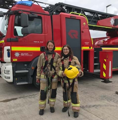 Thompsons' solicitors dressed as firefighters standing in front of a fire engine.